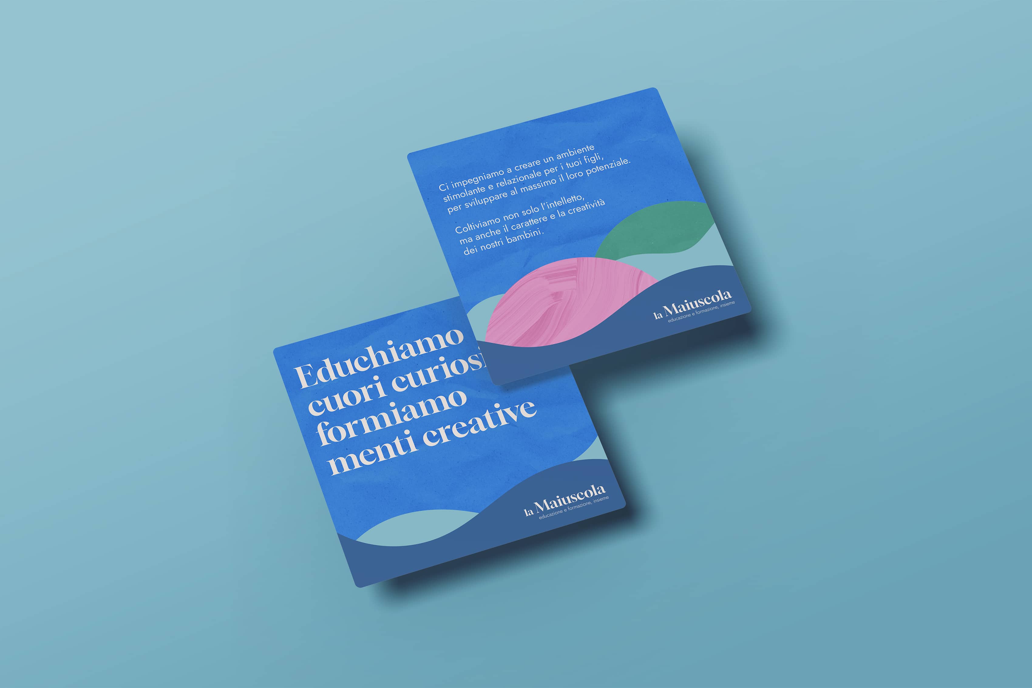 Two blue square cards with Italian text about education and creativity, featuring abstract wave designs and the la Maiuscola logo.