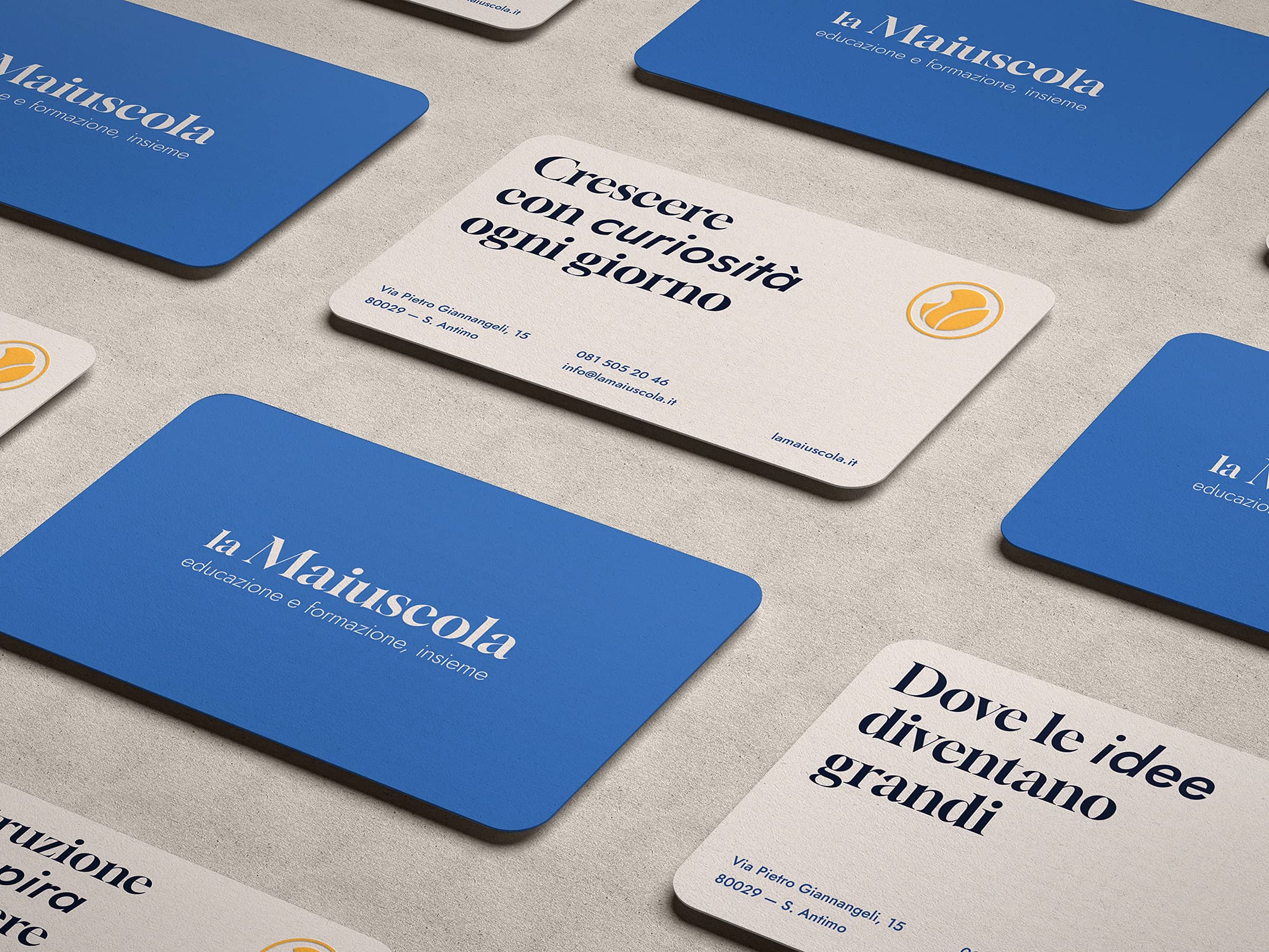 Business cards for la Maiuscola, featuring blue backs with the logo and white fronts with Italian text and contact information.