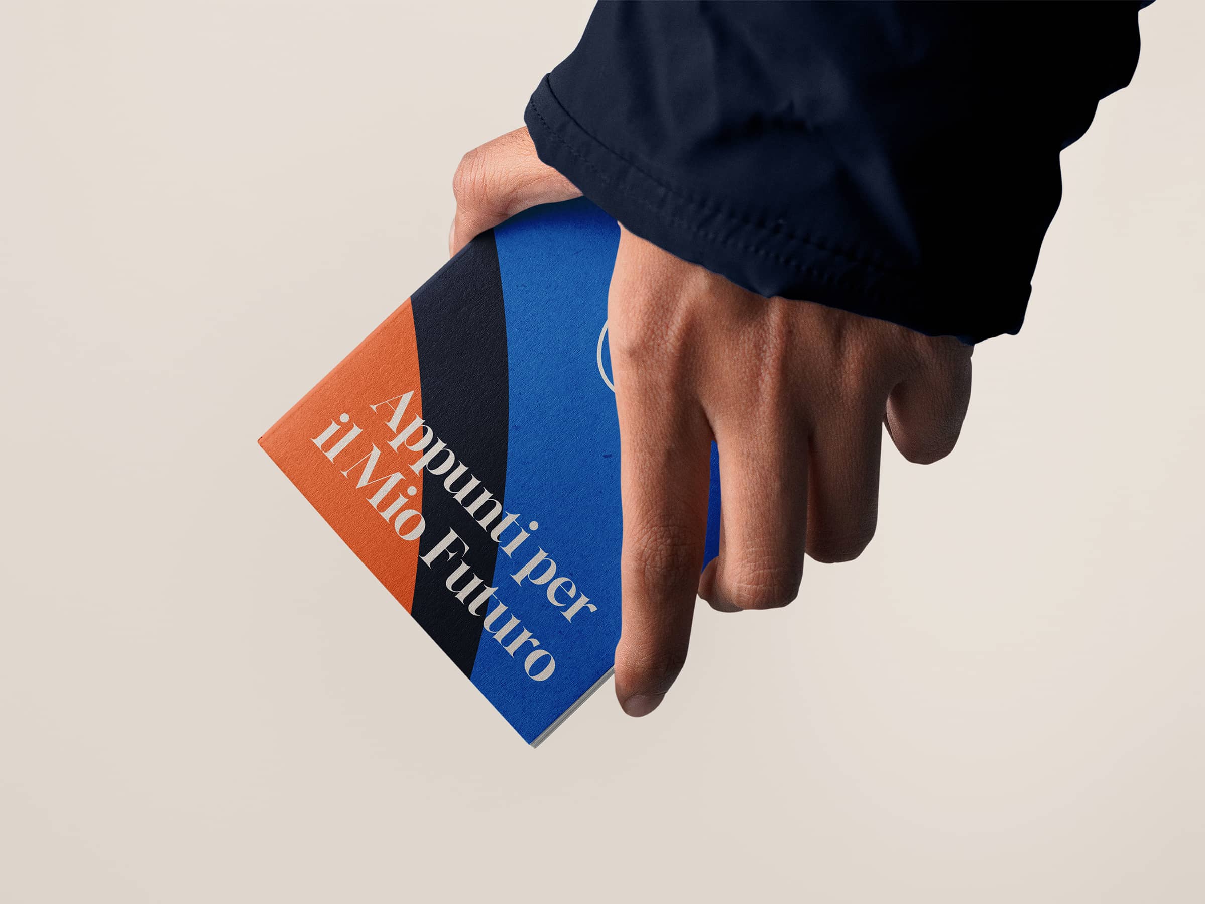 Hand holding a multicolored notebook with the Italian text 'Appunti per il Mio Futuro' on the cover.
